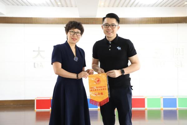 大連市西崗區五四路小學與本校梁俊傑校長互相致贈紀念旗。