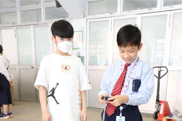 服務生向同學講解如何操作機械人。