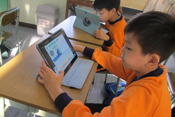 學生正在透過應用程式進行平板電腦互動學習。